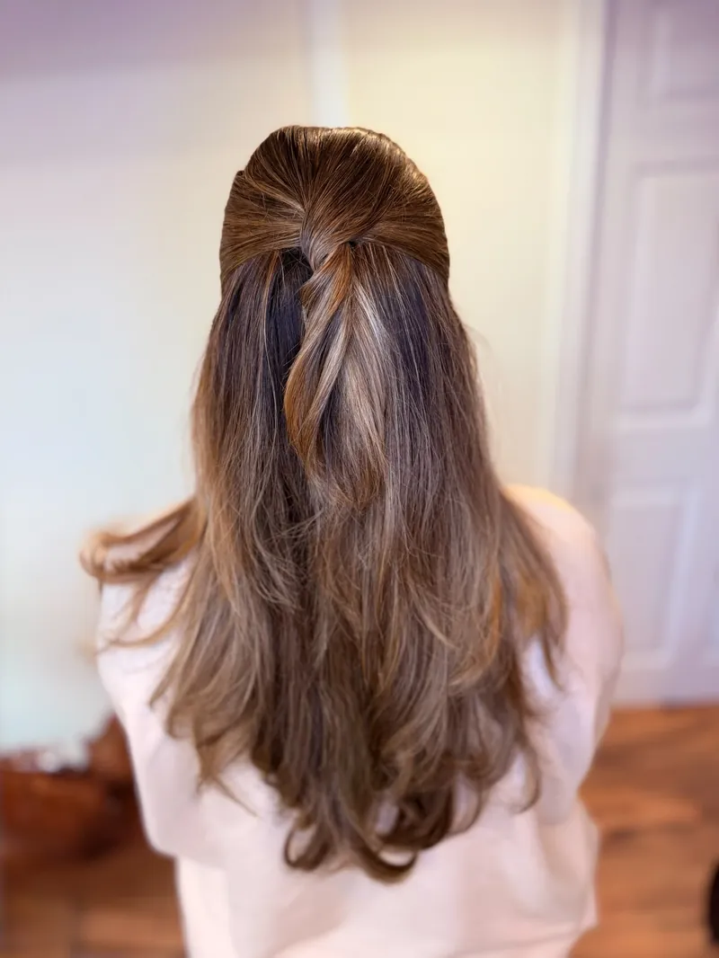 Brunette hair gathered into a soft low knot with loose face-framing strands